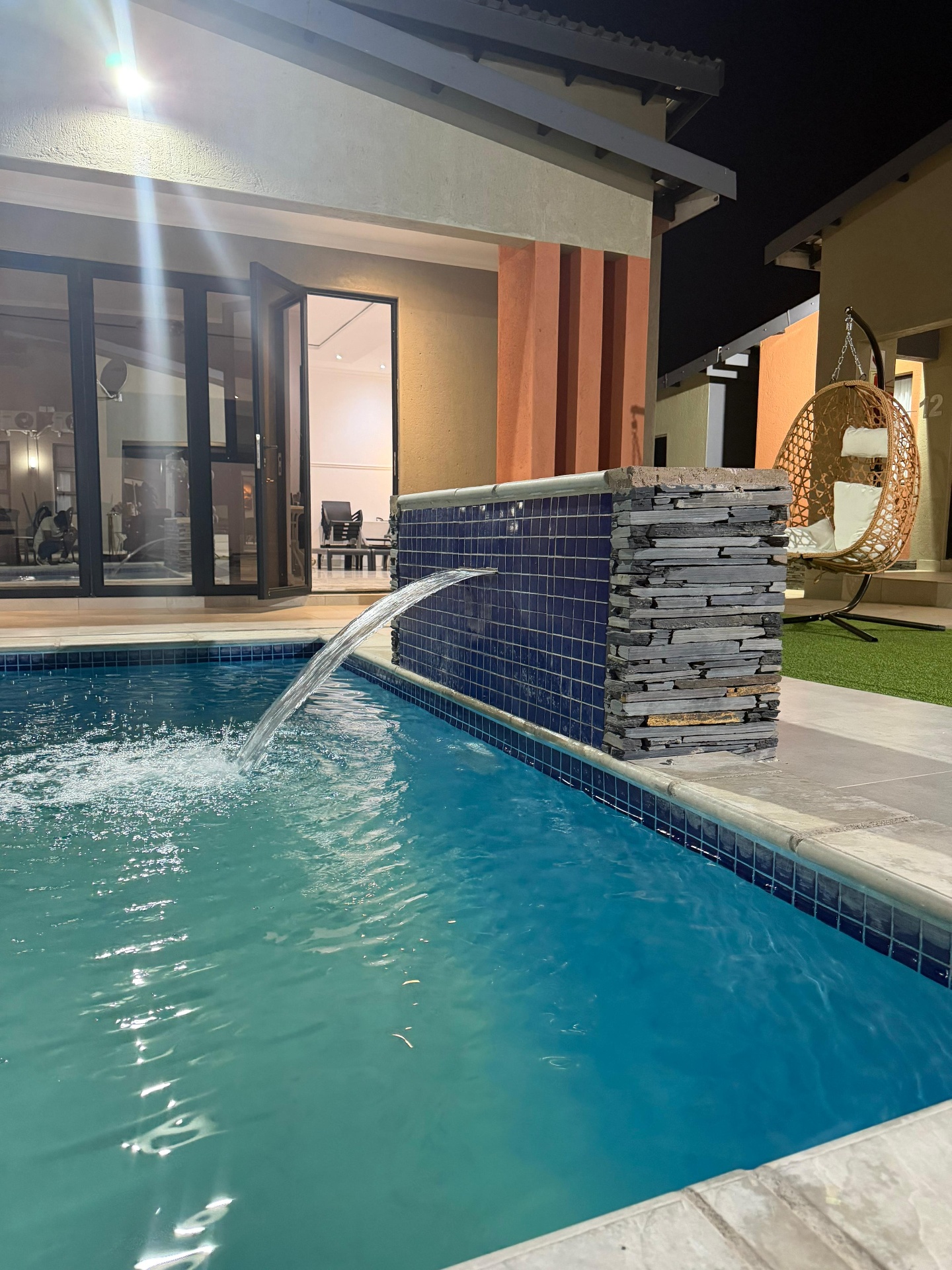 Pool with water feature at night